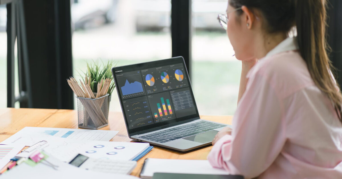 Marketing analyst working on a laptop in a cafe, planning campaign UTM tracking